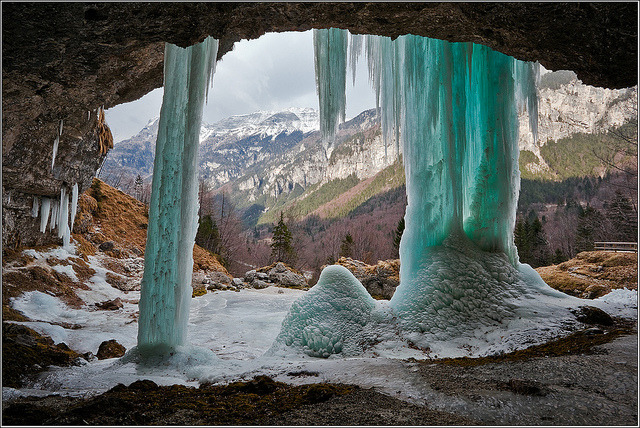 The frozen Fontana di Goriuda seen from behind, with the Julian Alps as a background, Italy